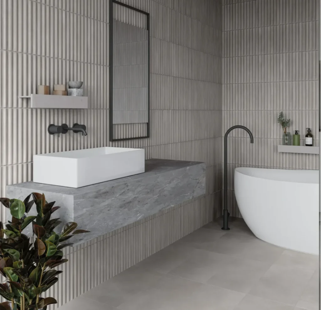 Modern bathroom tiling with textured wall tiles, floating vanity and freestanding bath installed by Stamford tiler.