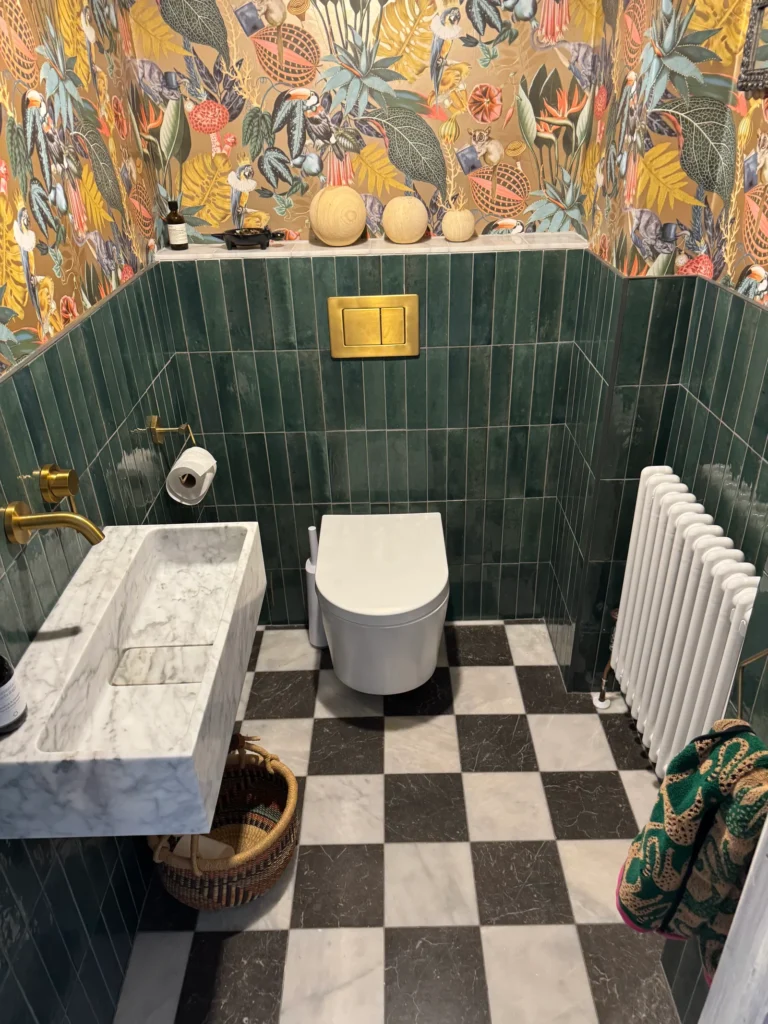 Cloakroom tiling with green wall tiles and black and white checkered floor installed by Stamford tiler covering Stamford, Oakham and Uppingham.