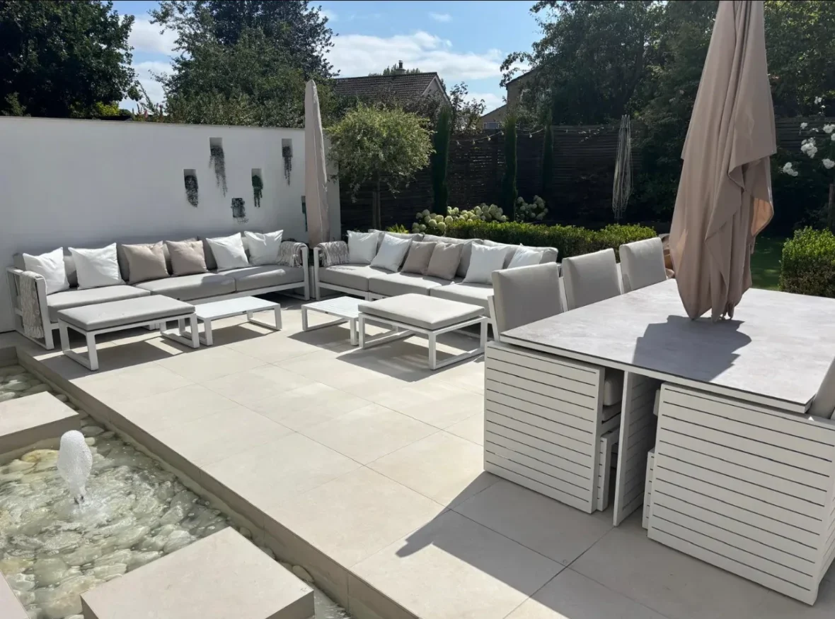 Large format outdoor porcelain patio tiling with modern garden seating area installed by Stamford tiler serving Stamford, Oakham and Uppingham.