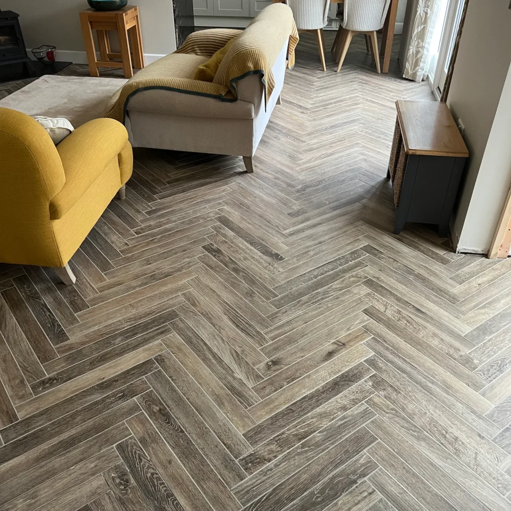 Wood effect herringbone floor tiles installed by Stamford tiler in a living room covering Stamford, Oakham and Uppingham.