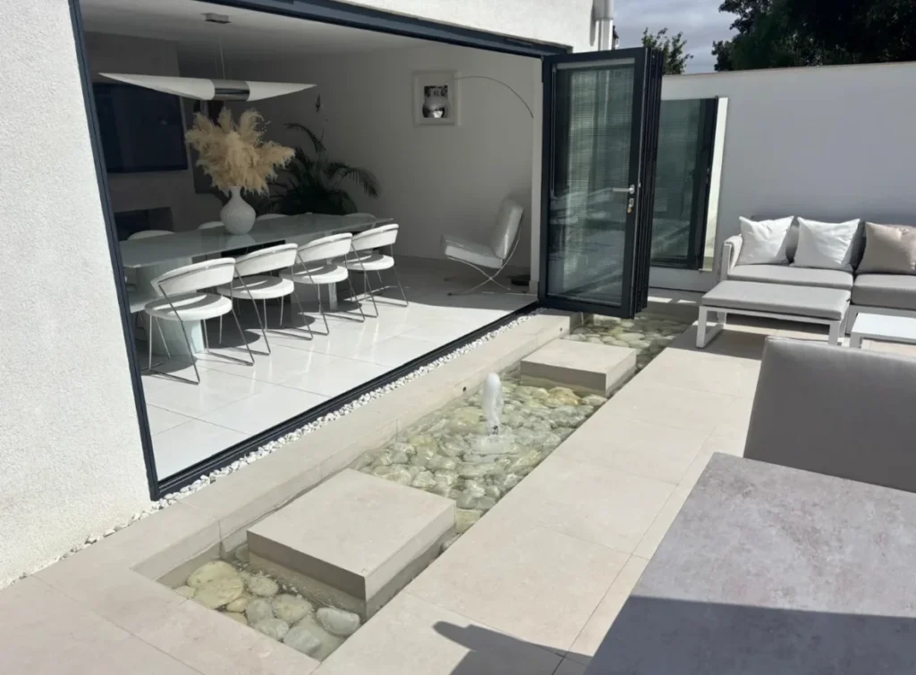 Outdoor porcelain patio tiling with water feature and stepping stones installed by Stamford tiler covering Stamford, Oakham, Uppingham and Peterborough.