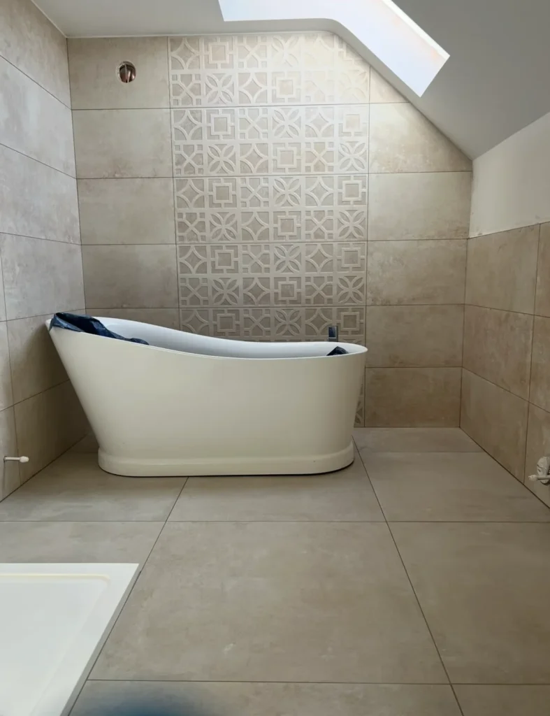 Bathroom tiling with decorative feature wall tiles and large format floor tiles installed by Stamford tiler covering Stamford, Oakham and Uppingham.