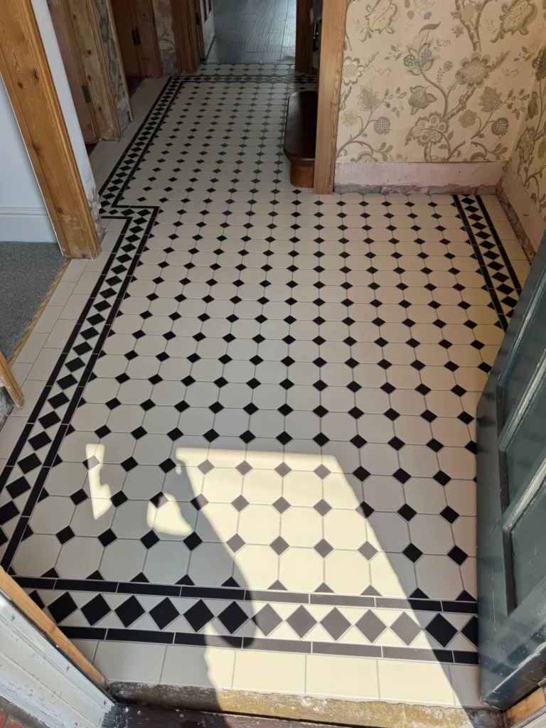 Victorian style hallway floor tiling with black and white patterned tiles and decorative border installed by Stamford tiler serving Stamford, Oakham and Uppingham.